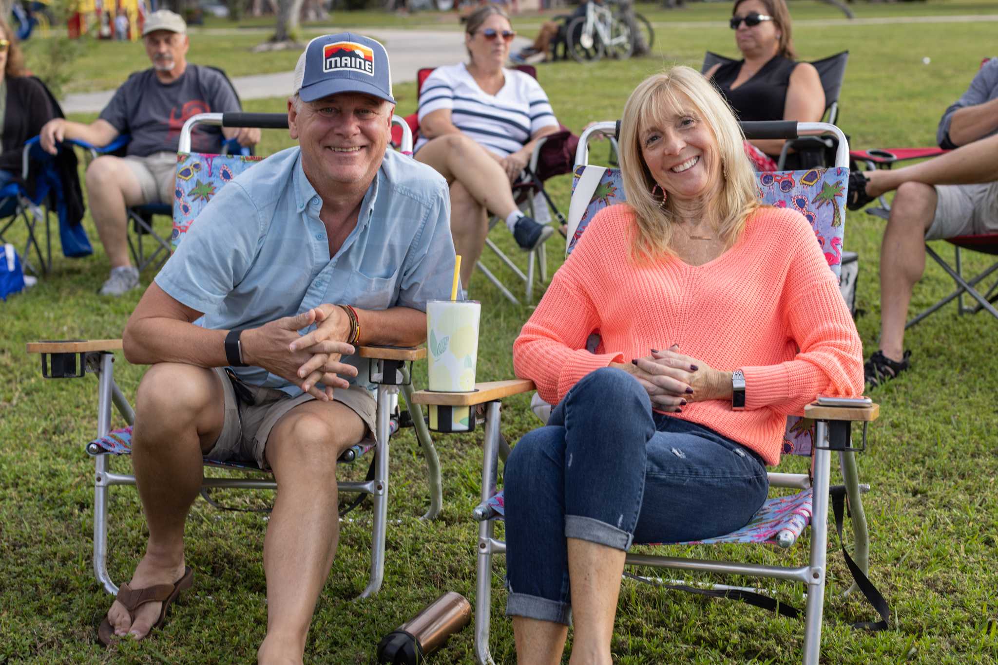 Couple smiling and sitting outdoors in lawn chairs